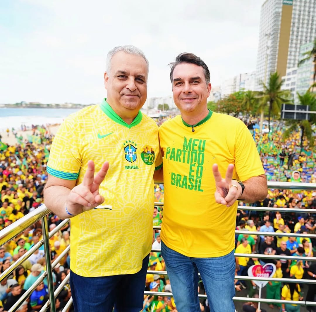 Flavio Bolsonaro, right, in the yellow Brasil shirt at a campaign rally on October 22, 2026, three days before the runoff he went on to lose. File photo.