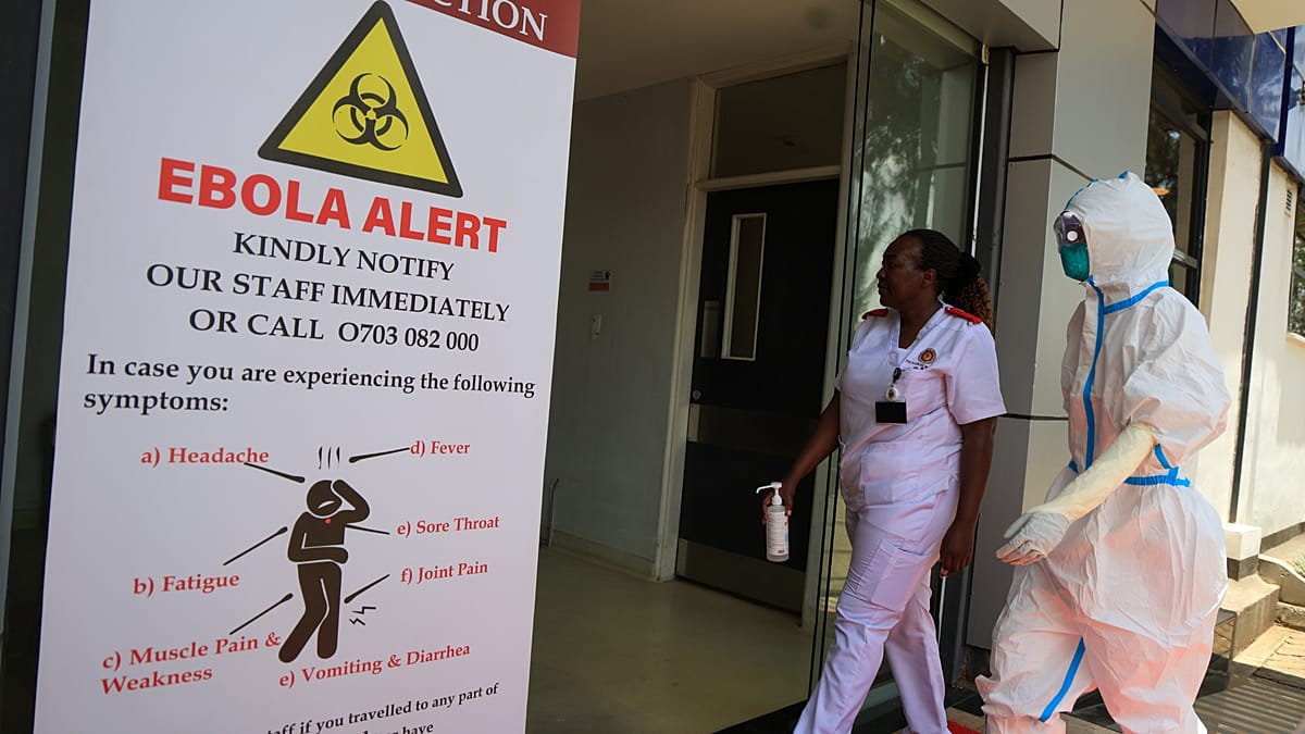 An Ebola alert sign at a medical facility in Nairobi, Kenya, as a health worker in protective equipment walks past. Kenya traced 135 contacts of its first case and placed them in quarantine.